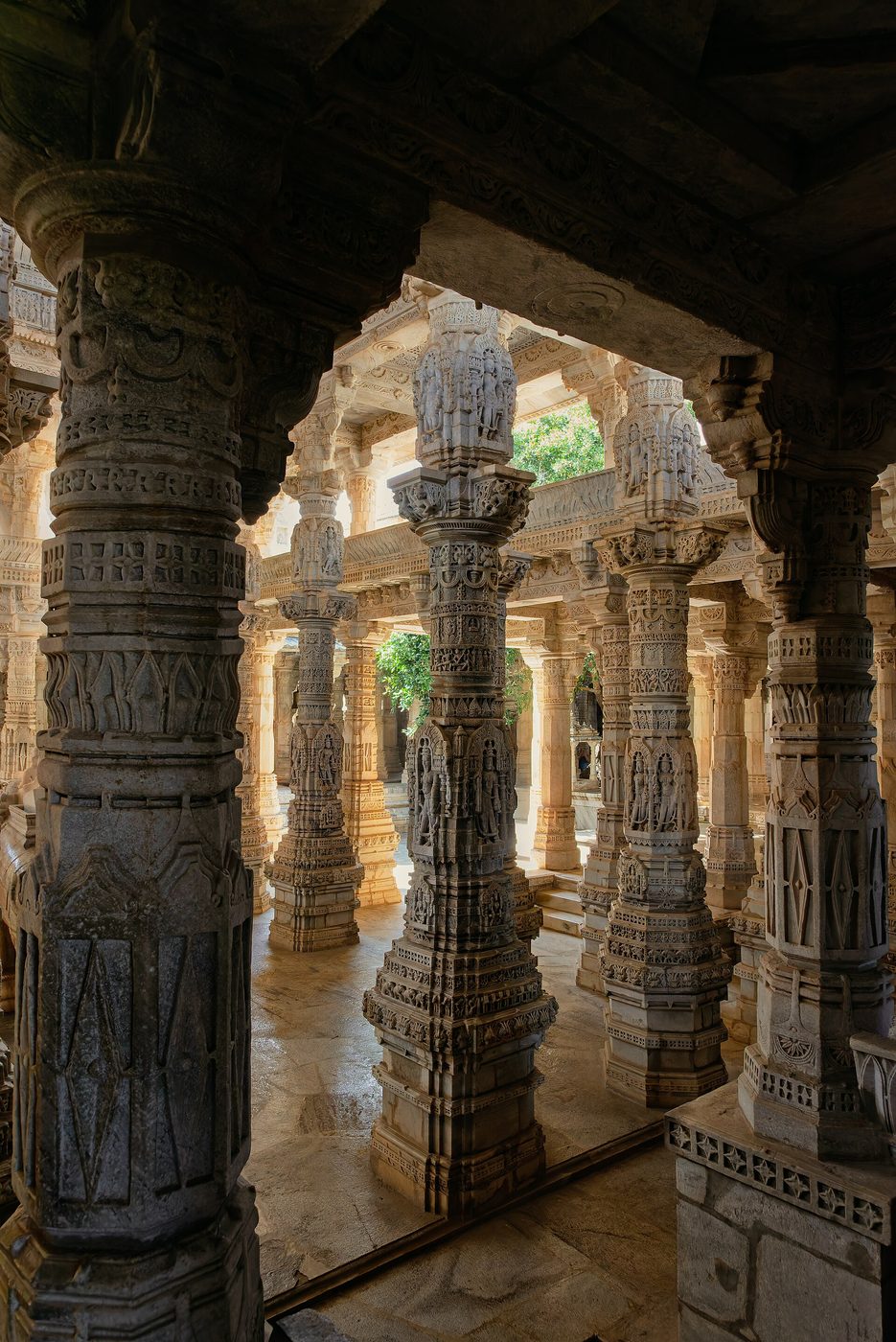 A pillared stone hall in deep shade, kept for seated silence
